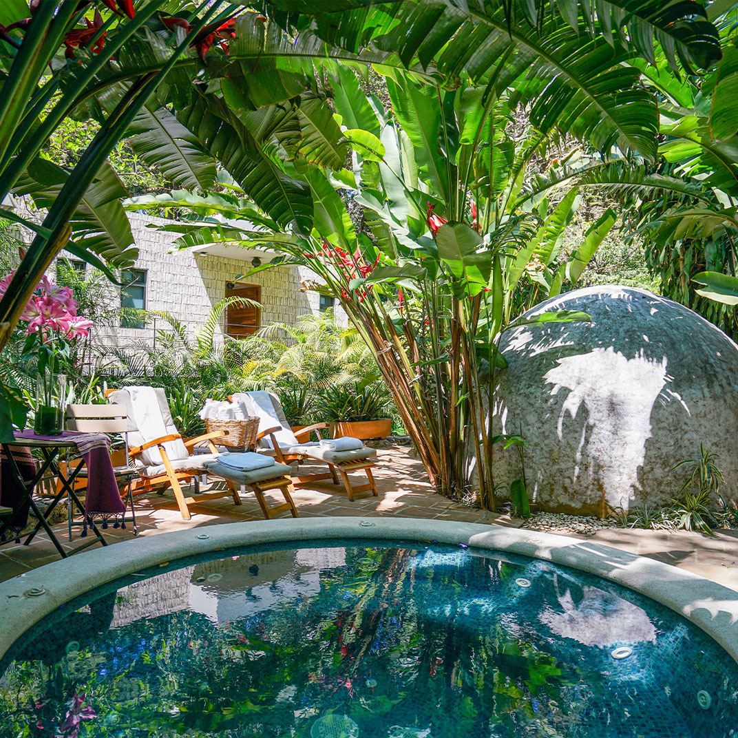The entrance to Amomoxtli takes you over a 200-year-old stone bridge framed by tropical gardens. © Amomoxtli