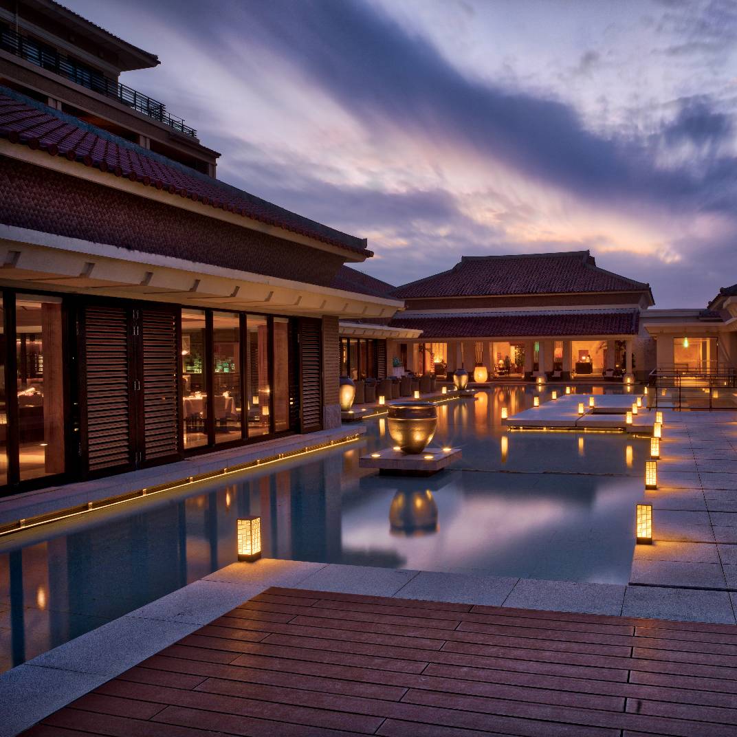 The Ritz-Carlton Okinawa’s serene terrace, where traditional Japanese architecture meets tranquil reflection pools, glows at twilight. © The Ritz-Carlton, Okinawa 