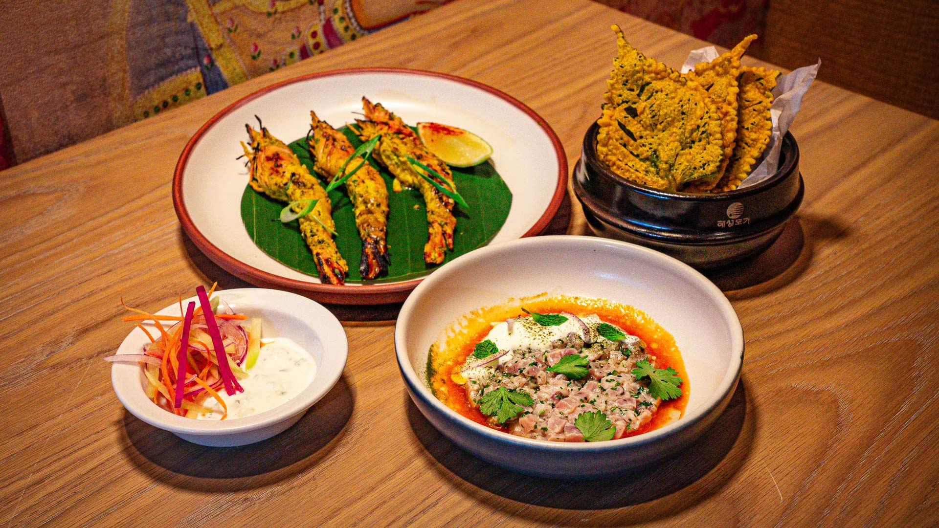 Grilled gulf shrimp with ajwain yogurt, cured hamachi, and sesame leaf pakoda at Eylan. ©Eylan